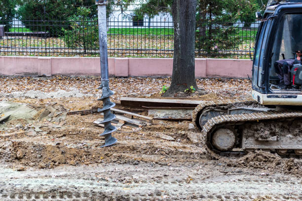 都市道路の再建のために土工を行う際に土を掘削するためのオーガー付きトラクター。 - mining drill geotechnical borehole ストックフォトと画像