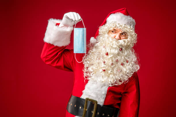 istock Santa Claus looking disapprovingly at protective face mask. 1290866144