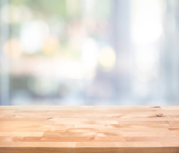 istock Empty wood table top on blur abstract  window glass view. 1290866342