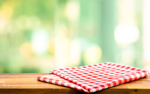 istock Cloth napkin on wood table with glass window background 1290867242
