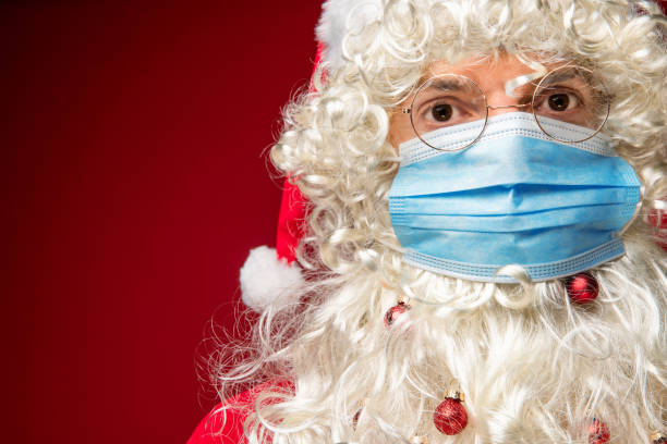istock Santa Claus wearing protective face mask on red background. 1290869390