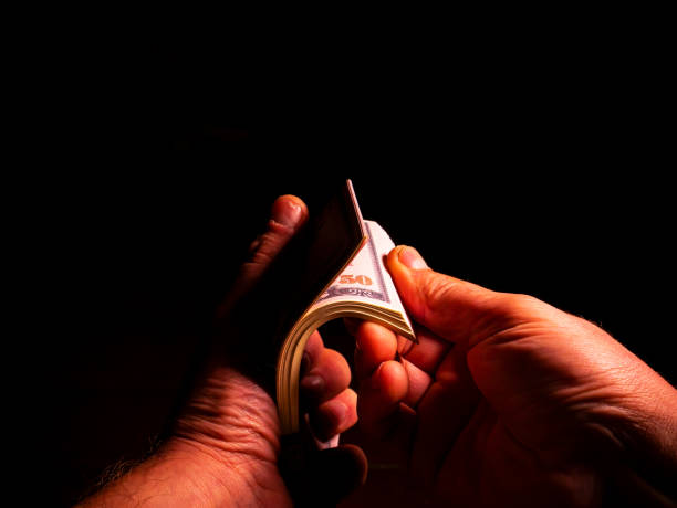 istock Mans hands are counting money in the dark. 1290869439