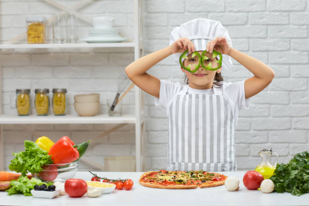 a criança segurando pimentões de sino verde - pizza sauces chef making - fotografias e filmes do acervo