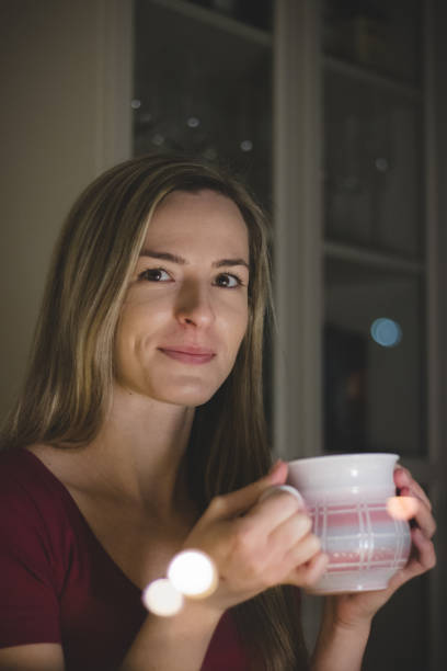istock challenging look at her lover through the window. A nice blonde waits for her loved one at the dinner table. The glamorous expression of a European woman. Drinking hot tea 1290871529
