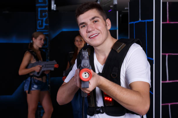 istock Guy holding laser pistol during playing lasertag with  friends in labyrinth 1290872067