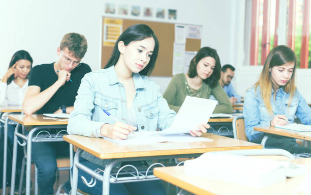 istock schoolgirl is sitting test and answer about task 1290874455