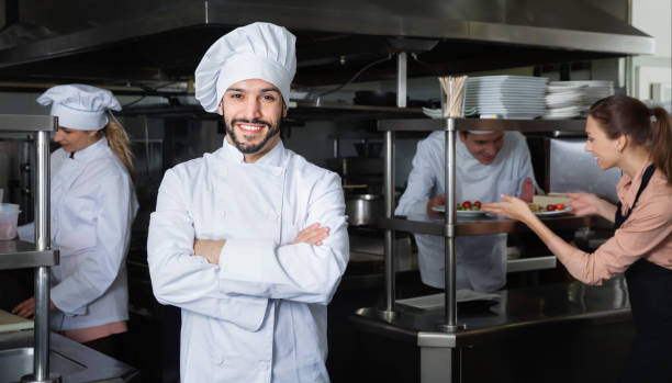 istock Portrait of satisfied smiling chef on restaurant kitchen 1290876320