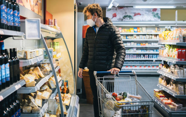 istock Young man wearing protective face mask shops in grocery store 1290877685