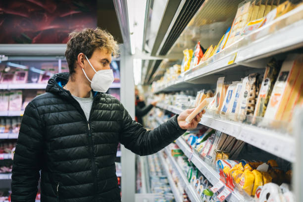 istock Young man wearing protective face mask shops in grocery store 1290877755
