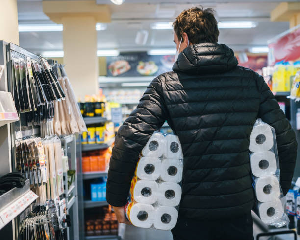 Young man wearing protective face mask shops in grocery store