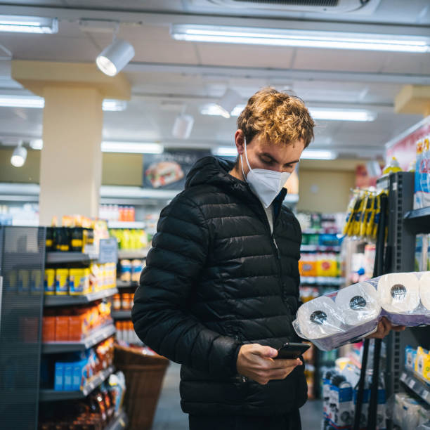 istock Young man wearing protective face mask shops in grocery store 1290877762
