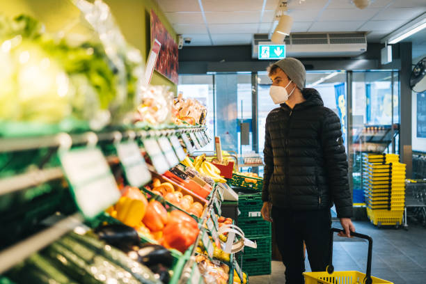 istock Young man wearing protective face mask shops in grocery store 1290877826