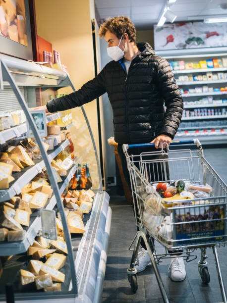 istock Young man wearing protective face mask shops in grocery store 1290877831