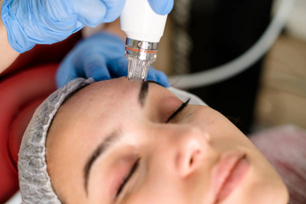 istock Cosmetologist making mesotherapy treatment on a woman's face 1290878229