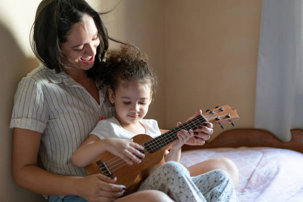 zia che insegna a sua nipote a suonare uno strumento musicale - childrens music foto e immagini stock