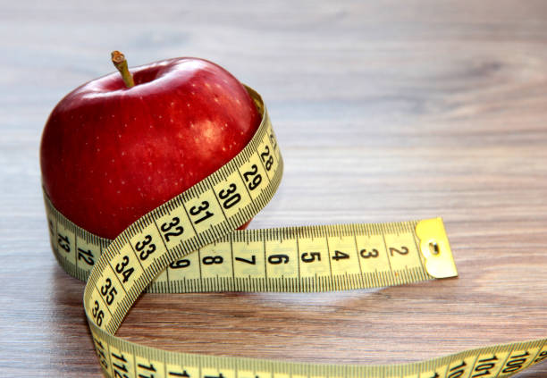 istock A red Apple is measured by a meter. Slimness and diet. 1290879469
