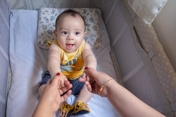 istock mother lifting baby in crib 1290880379