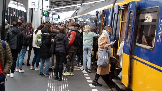 People Wearing Non Medical Face Mask Due To COVID-19 Pandemic, Standing, Preparing For Train Boarding, Boarding Train During Winter Season At Breda Central Railway Station In North Brabant The Netherlands Europe