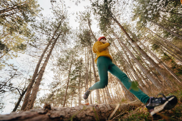 istock Young woman running in the woods 1290883080