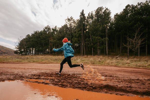 Photo of a young woman running on a cold morning, showing her persistence and endurance on extreme terrain