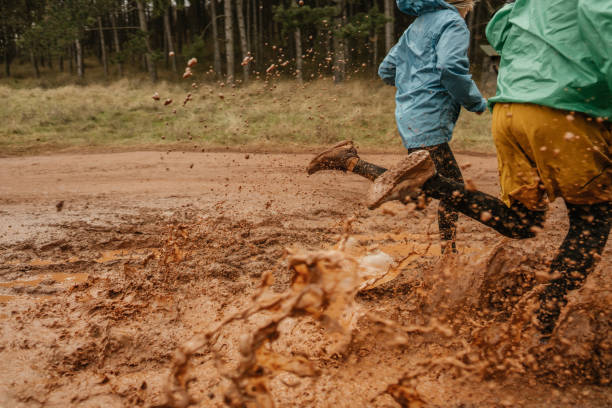 Photo of a persistent sporty couple, who enjoy working out together, jogging in the woods, on a rainy day - testing their endurance on extreme conditions and bad weather