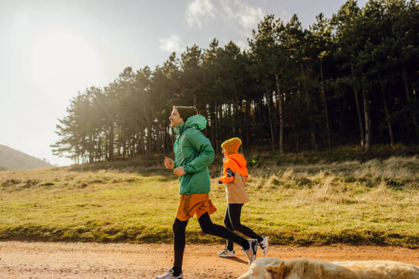 istock Young couple jogging together on a sunny winter day 1290886598