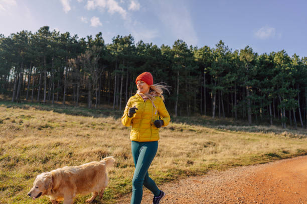 istock Young woman jogging with her dog 1290888273