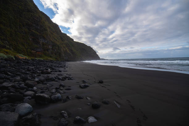 istock volcanic sand beach with polished rocks 1290891615