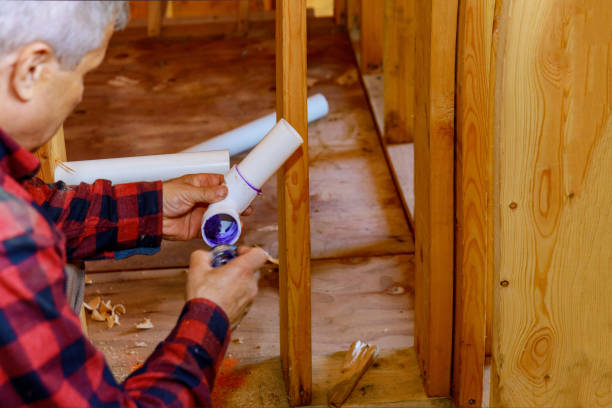 istock Plumber joining PVC sewage drain pipes on a home under construction 1290892982