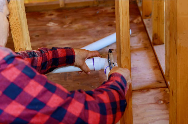 istock Hands plumber in installing of plastic drains PVC pipe, closeup on new bathroom 1290892983