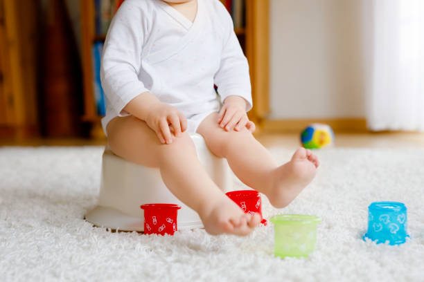 Closeup of cute little old toddler baby girl child sitting on potty. Kid playing with educational toy and Toilet training concept. Baby learning, development steps. No face, unrecognizable person. Closeup of cute little old toddler baby girl child sitting on potty. Kid playing with educational toy and Toilet training concept. Baby learning, development steps. No face, unrecognizable person potty toilet child bathroom stock pictures, royalty-free photos & images