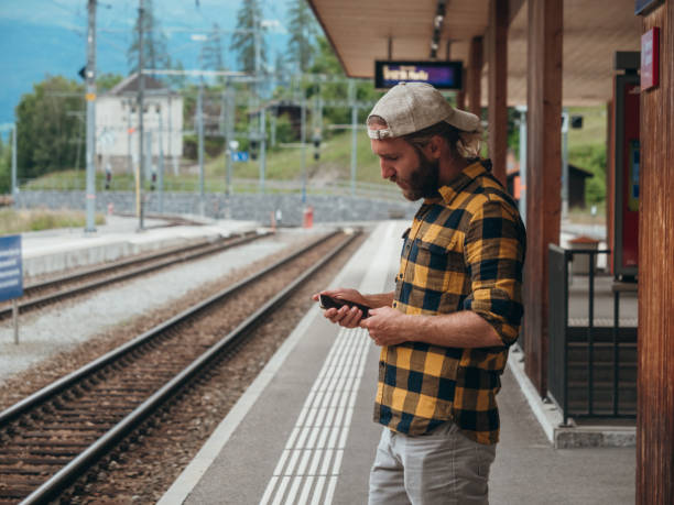 istock Man checks phone at train station 1290893442