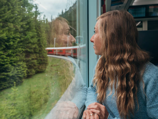 istock Woman traveling by train looking from the window enjoying passing scenery 1290893469