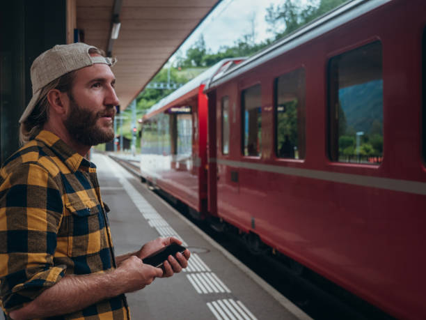 istock Man checks phone at train station 1290893511