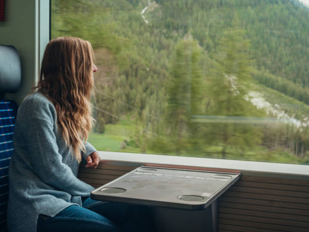 지나가는 풍경을 즐기는 창에서 바라보는 기차로 여행하는 여성 - graubunden canton switzerland station mountain 뉴스 사진 이미지
