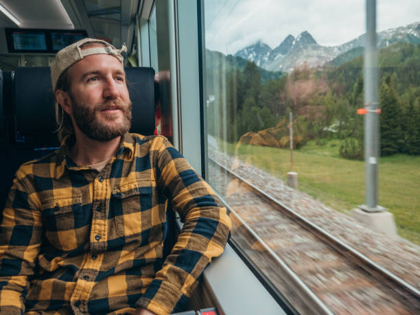 istock Man traveling by train looking from the window enjoying passing scenery 1290893569