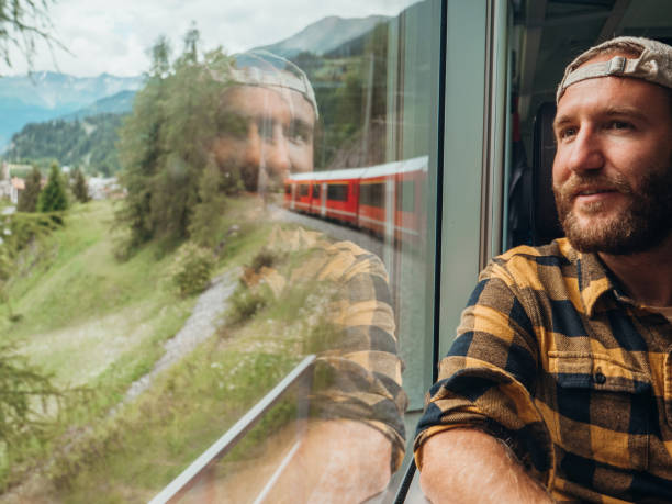 istock Man traveling by train looking from the window enjoying passing scenery 1290894124