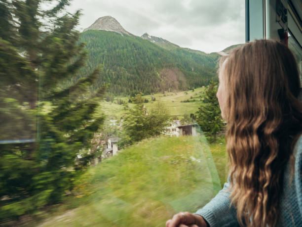 istock Woman traveling by train looking from the window enjoying passing scenery 1290894143