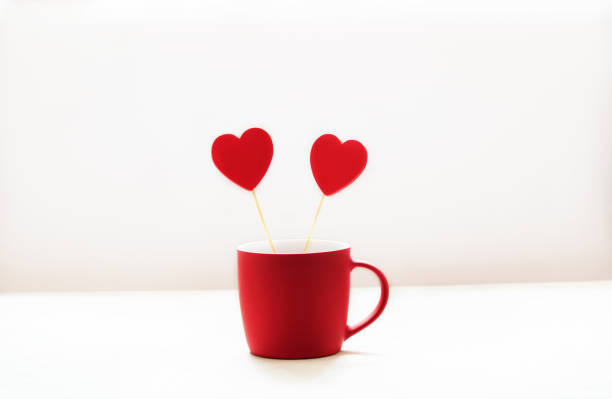 istock Red wooden hearts in a red cup on a white background 1290895767
