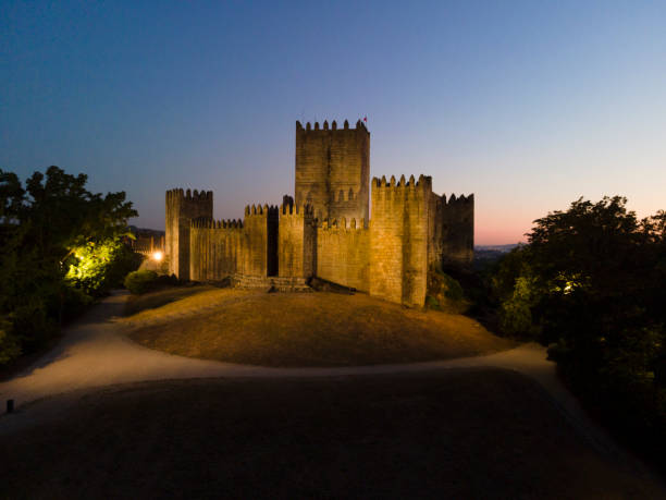 Guimarães Castle at Nitht Guimarães, Portugal 28/7/2020: Guimarães Castle is connected to the birthplace of Portuguese nationality, it was here that King D. Afonso Henriques was born and founded the county of Portugal and the struggles for the independence of Portugal against the kings of Castile. The Castle is located on a hill and is classified as a national monument and represents one of the great historical landmarks of our country. braga district stock pictures, royalty-free photos & images