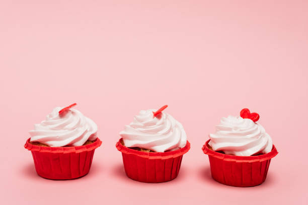 istock valentines cupcakes with red heart on pink background 1290898211