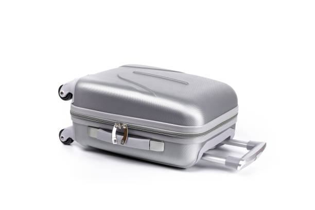 istock Travel suitcase isolated. Silver plastic luggage or vacation baggage bag on white background. Design of summer vacation holiday concept. 1290902408