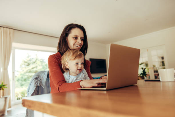 istock Woman with baby working on laptop 1290905142