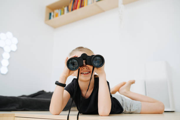 istock A boy of 8 years looks through binoculars and smiles 1290906656
