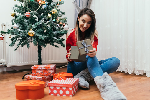 Young beautiful girl with Christmas present box at home