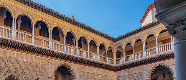 SEVILLE, SPAIN - OCTOBER 18.2020: Palace of Alcazar in Seville, Famous Andalusian Architecture. Old Arab Palace in Seville, Spain. Ornamented Arch and Column. panorama