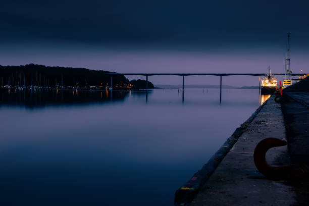 Evening view of city Vejle harbour, Denmark. A long exposure renders the water silky soft. the background is the Vejlefjord Bridge, part of highway E45.