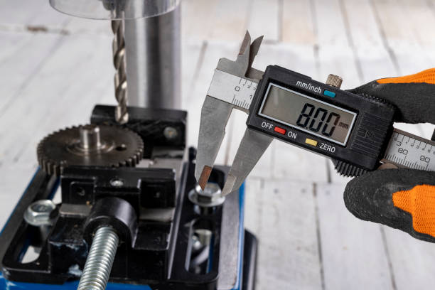 istock Drilling a hole in metal. Metal works performed with a drill. Dark background. 1290909659
