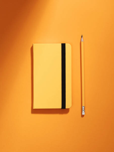 istock Monochromatic still life with notebook and pencil. 1290909707