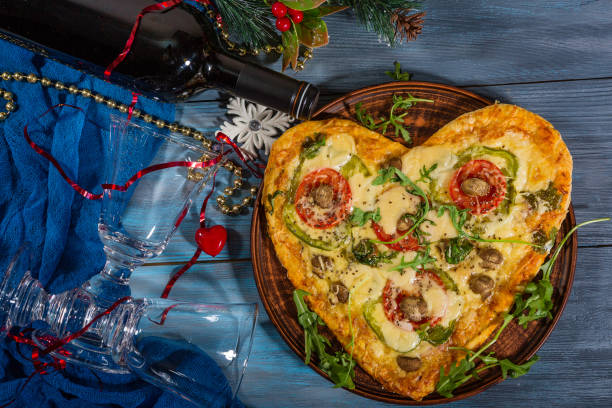 istock Heart-shaped pizza and a bottle of wine 1290910690